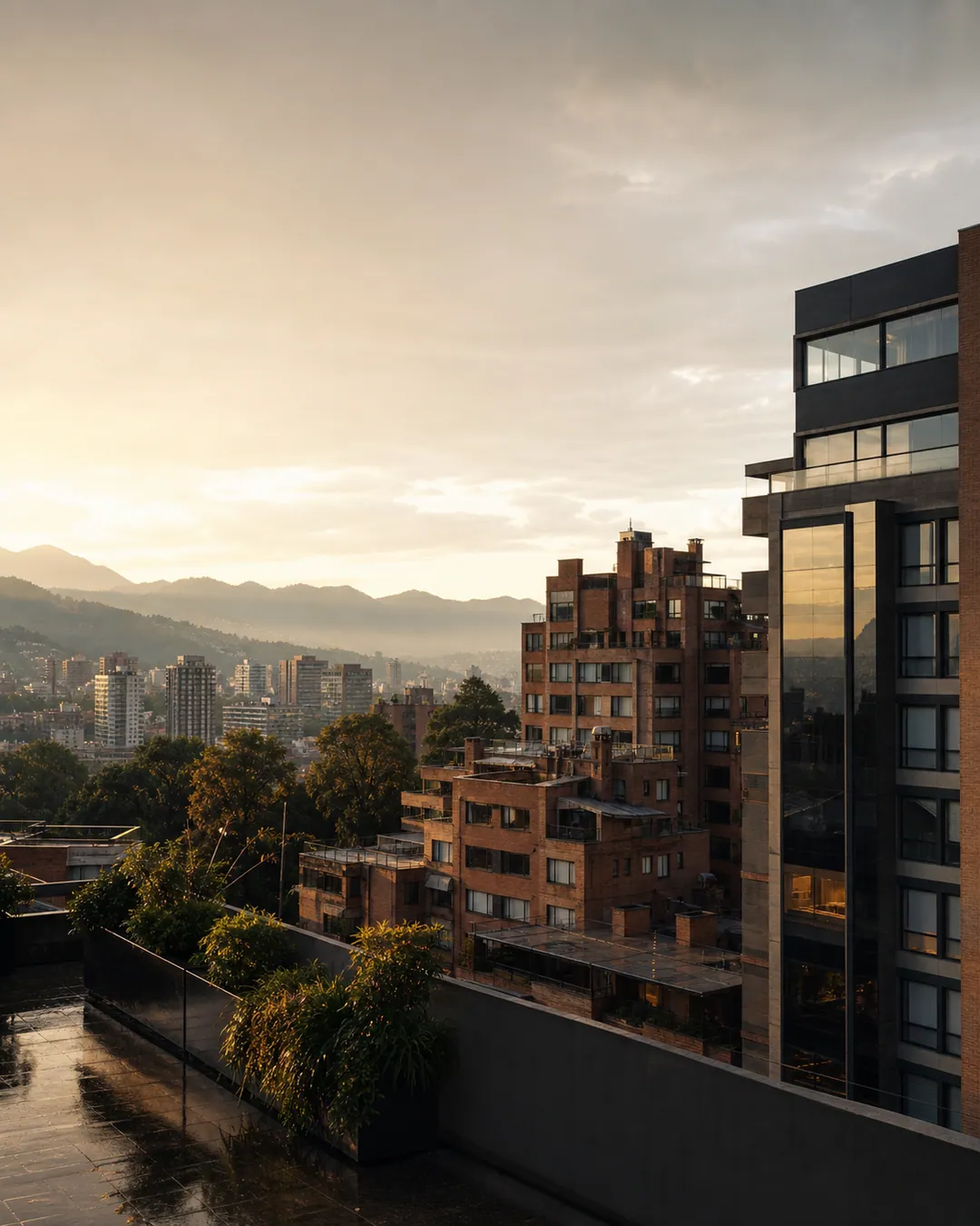 Panorama residencial de Bogotá con edificios de ladrillo y montañas al fondo después de la lluvia.